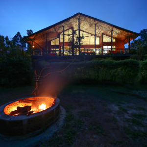 Feuerstelle und Hauptgebäude am Abend