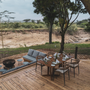 Lounge mit Feuerstelle und gedeckter Esstisch